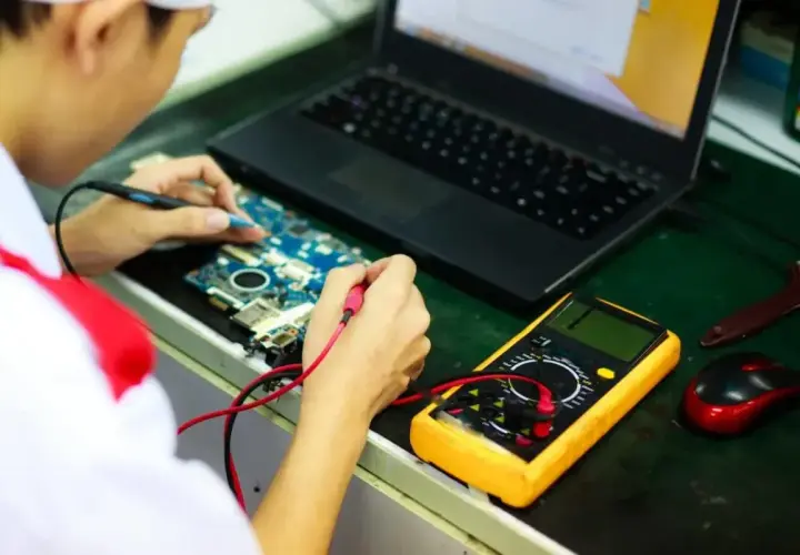 Inżynier elektroniki bada płytę główną z multimetrem. Zastanawiasz się, ile zarabia inżynier elektroniki?