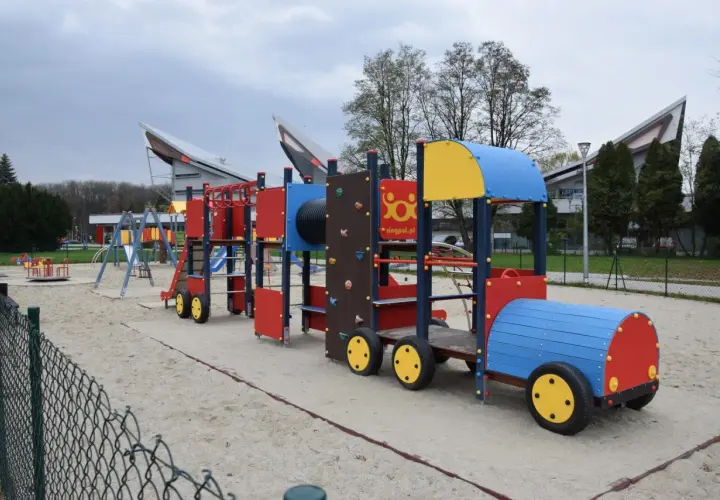 Kolorowy pociąg na placu zabaw w parku rozrywki Zawada. Dzieci mogą wspinać się, zjeżdżać i bawić się na tej interaktywnej konstrukcji.
