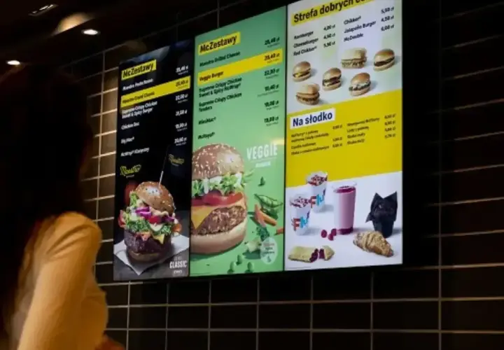 Menu McDonald's z cenami. Widoczne McZestawy, burgery, a także oferta "Na słodko". 6 nuggetsow mcdonald cena jest widoczna na ekranie.