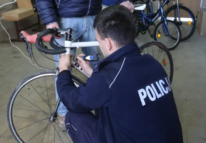 Policjant sprawdza rower, by ustalić, jak sprawdzić czy rower nie jest kradziony.