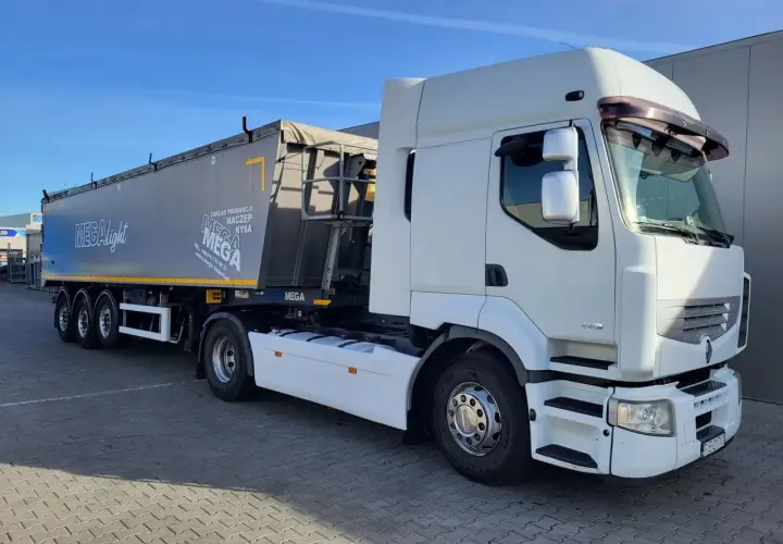 Biała ciężarówka Renault Premium z naczepą MEGA, gotowa do trasy.