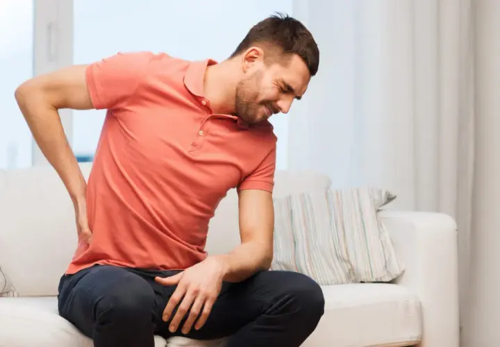 Mann mit Rückenschmerzen sucht nach hallux schmerzen lindern hausmittel.