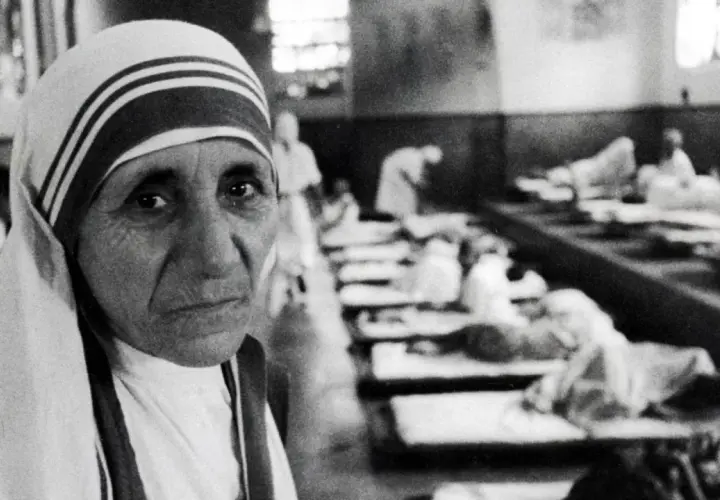 Mutter Teresa im Vordergrund, im Hintergrund Kranke in Betten. Die Aufnahme wirft Fragen auf, die zu Kritik an Mutter Teresa führten.