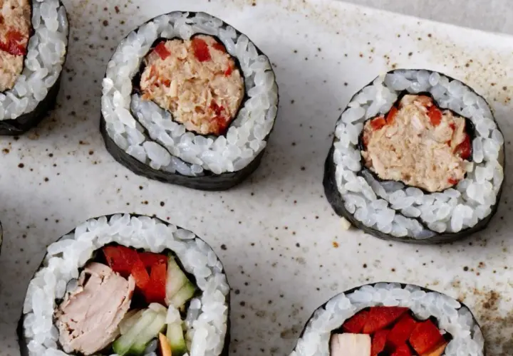 Roladki sushi z ryżem i nori, wypełnione rozdrobnionym tuńczykiem w sosie własnym, papryką i ogórkiem.