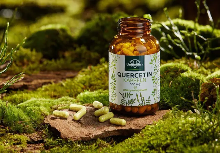 Braune Flasche mit Quercetin-Kapseln, umgeben von Moos. Hilft bei einer Quercetin-Allergie, indem es die natürliche Abwehr unterstützt.