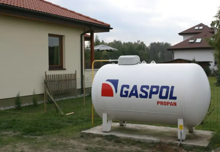 Zbiornik na gaz propan obok domu. Ogrzewanie domu gazem z butli 33 kg koszty są kluczowe dla budżetu.