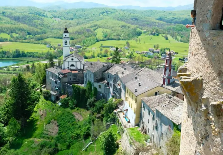Borgo pittoresco sull'Appennino Romagnolo, con chiesa e campanile che dominano il paesaggio verdeggiante. Un luogo incantevole da scoprire.