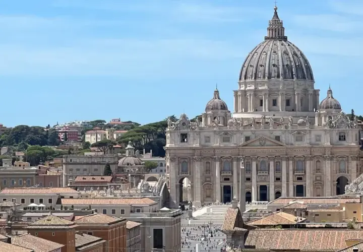 Vista panoramica di Roma con la Basilica di San Pietro in primo piano. Si intravedono i tetti della città e il cielo azzurro. Vicino alla stazione Ottaviano, un luogo iconico.