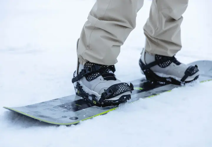 Zbliżenie na buty snowboardowe w wiązaniach. Dowiedz się, jak ustawić wiązania snowboard, by cieszyć się jazdą.