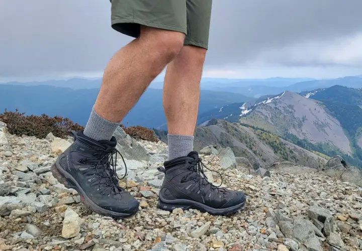 Hiking boots on a rocky summit. These boots look like they could last for years, answering the question: how long do leather boots last?