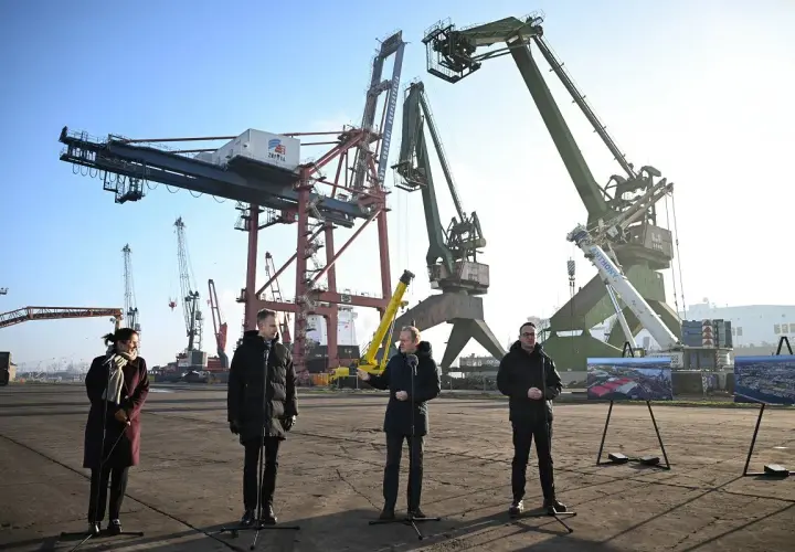 Ludzie stojący przed dźwigami portowymi w Gdańsku.