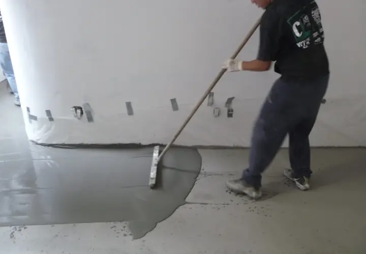 Man behandla betonggolv inomhus med en bredspackel för att jämna ut det flytande materialet.