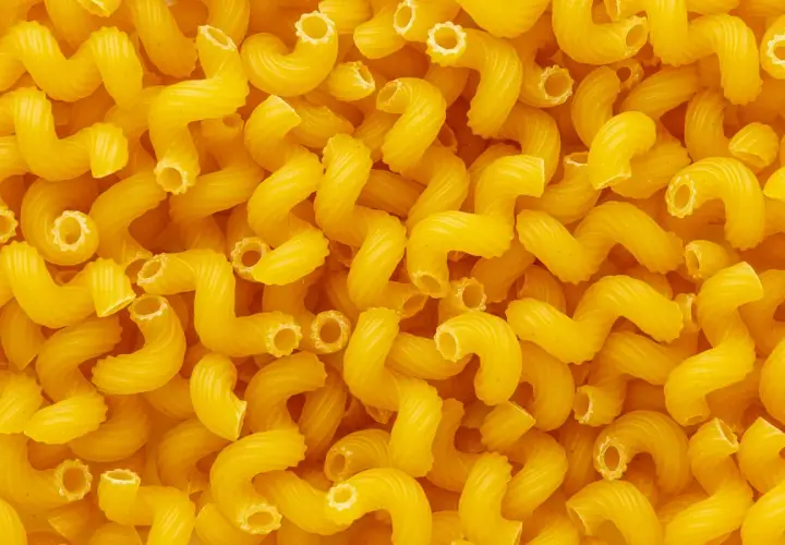 Góra żółtego makaronu cavatappi. Zastanawiasz się, ile białka ma makaron?