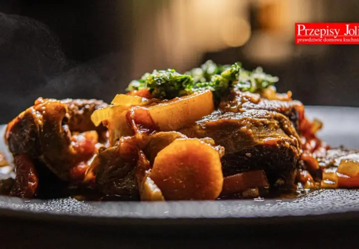 Pyszne, parujące ossobuco wołowe z warzywami na talerzu. Aromatyczne danie, które rozpływa się w ustach.