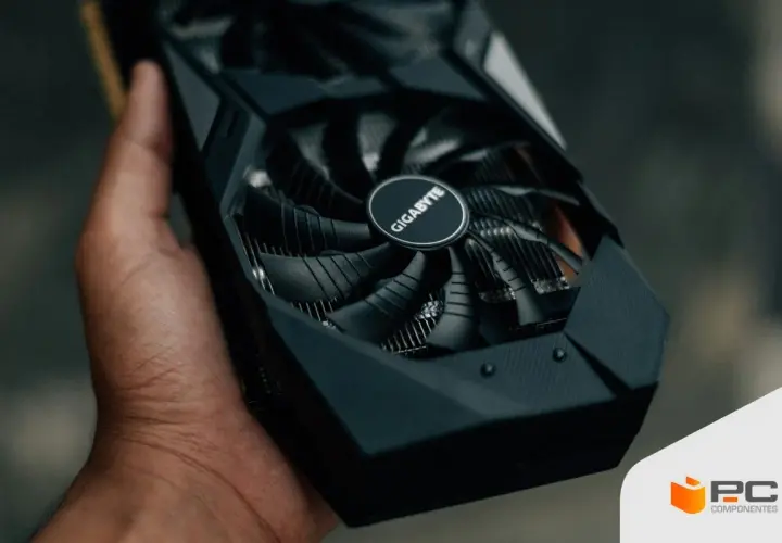 Mano sostiene una tarjeta gráfica Gigabyte, esencial para el rendimiento de tu PC.