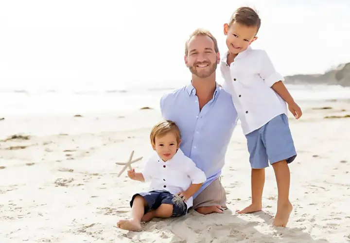 Nick Vujicic z synami na plaży.