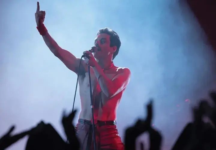Rami Malek jako Freddie Mercury śpiewa w "Bohemian Rhapsody", porywając tłum gestem i głosem.