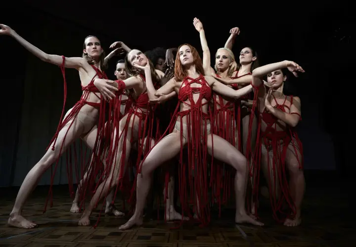 Danzatrici in abiti rossi intrecciati, un'immagine evocativa per la recensione di Suspiria 2018.