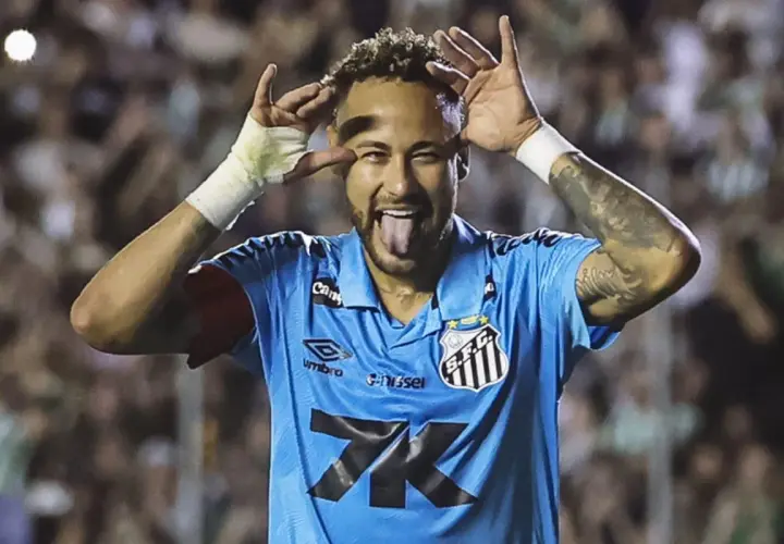 Neymar, w niebieskiej koszulce Santos, z językiem na wierzchu i rękami przy oczach, świętuje bramkę. Czy to zapowiedź jego kolejnego transferu?