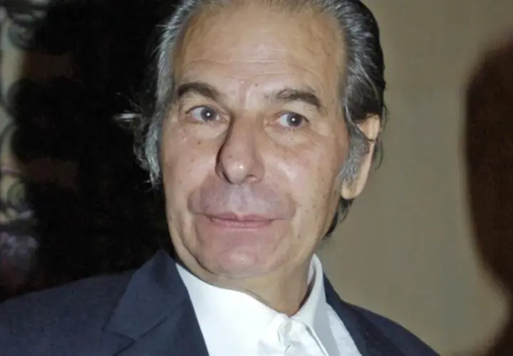 Retrato de Paulita Torero, un hombre mayor con cabello canoso y traje oscuro.