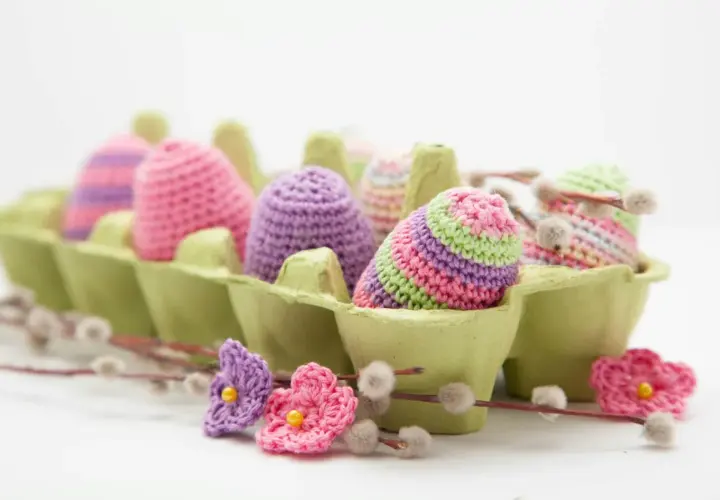 Uova di Pasqua all'uncinetto in un portauova verde, perfette per idee lavoretti con la lana facili e colorati.
