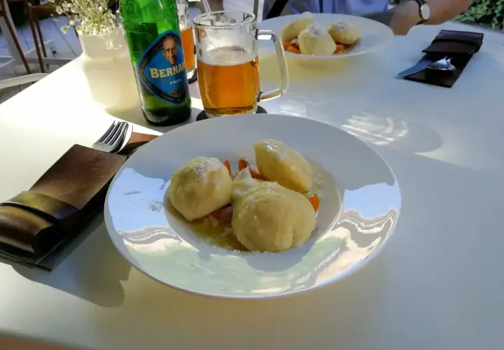 Ołomuniec gdzie zjeść? Pyszne knedliki z owocami i piwo Bernard na stole. Idealne miejsce na posiłek.