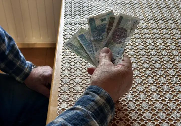 Dłoń trzyma polskie banknoty. Czy to odpowiedź na pytanie, ile zarabia opiekun wytchnieniowy?
