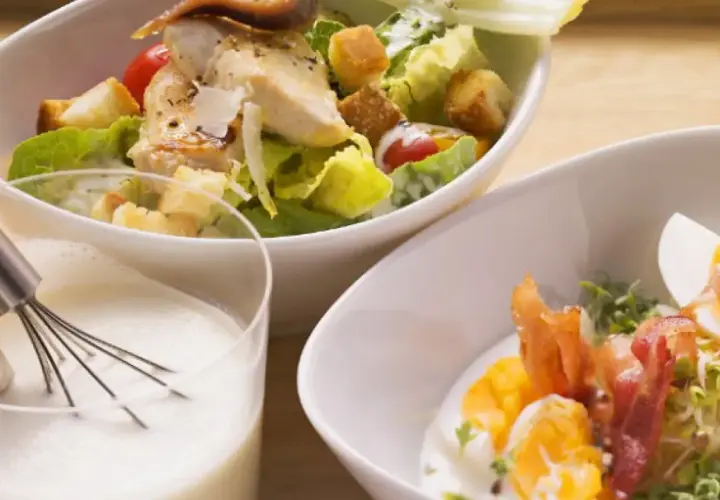 Ensalada César con pollo y huevo duro, acompañada de una cremosa salsa césar vegana.