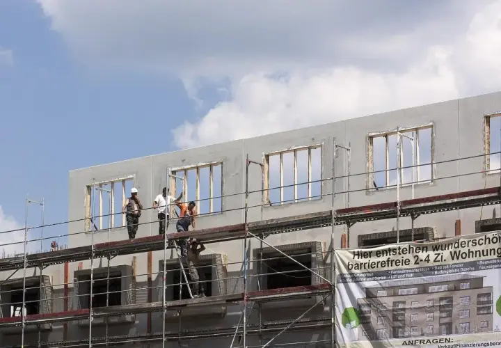 Chantiers de construction : des ouvriers sur des échafaudages travaillent sur un immeuble en cours de construction, projet de crédit immobilier avec travaux.