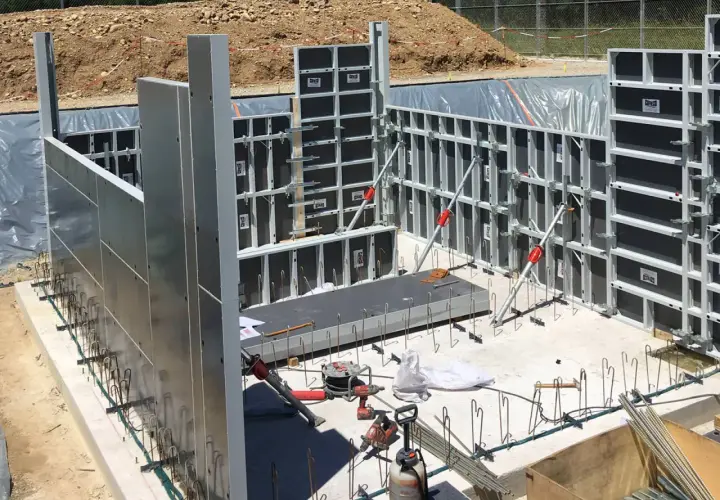 Panneaux de coffrage modulaires en aluminium et acier installés sur un chantier de construction.