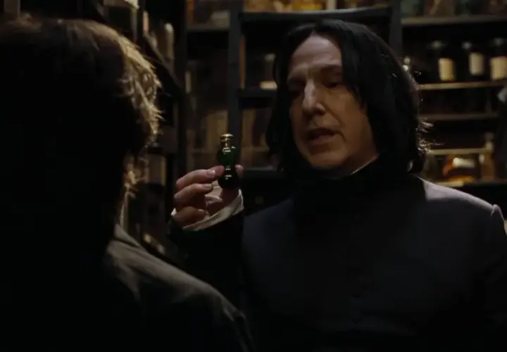 Severus Snape trzyma fiolkę z eliksirem, rozmawiając z kimś w mrocznym pomieszczeniu pełnym butelek.