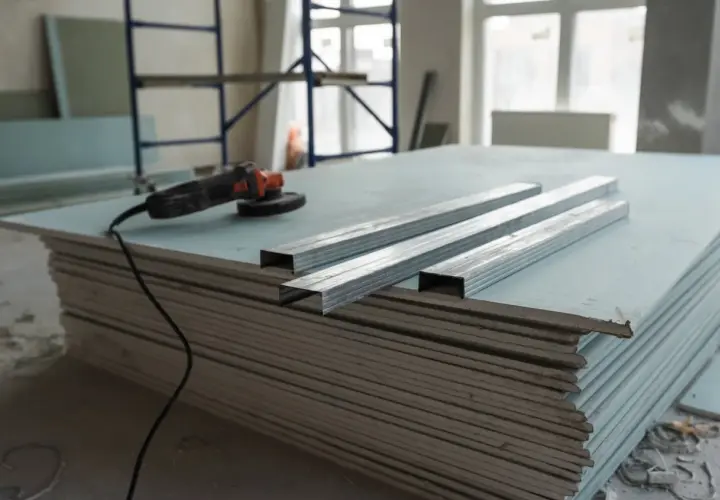 Materiali per un tutorial cartongesso: lastre, profili metallici e smerigliatrice.