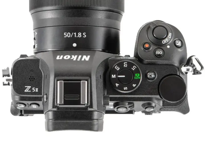 Górna część aparatu Nikon Z5 II z obiektywem 50/1.8 S. Widoczne przyciski sterujące, pokrętło trybów i logo Nikon.