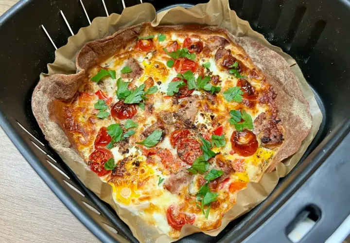 Pyszna tortilla z airfryer, z pomidorkami, serem i ziołami, gotowa do podania.