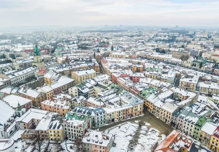 Zimowy krajobraz Lublina pokryty śniegiem. Idealne miejsce na ferie zimowe 2026 lubelskie, z kolorowymi kamienicami i zabytkowymi kościołami.