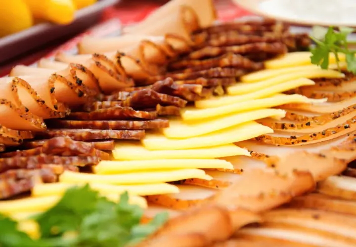Un plat convivial à partager : fines tranches de charcuterie et de fromage, garni de persil frais.