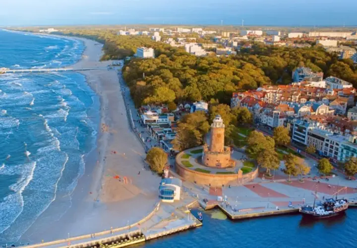 Malownicze miejscowości nad morzem z latarnią morską, plażą i portem.