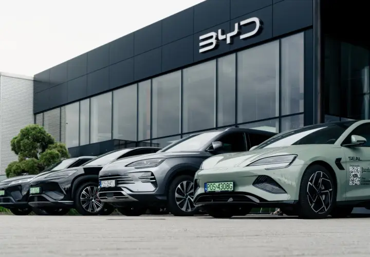 Rząd nowoczesnych samochodów BYD zaparkowany przed salonem. Wśród nich zielony model z napisem "Jazda testowa".