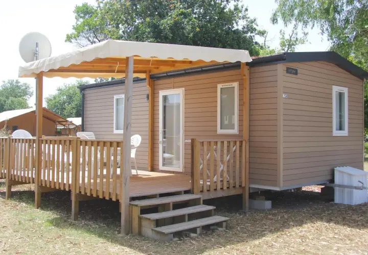 Mobil-home avec terrasse en bois et auvent, idéal pour un séjour camping car à Arcachon.