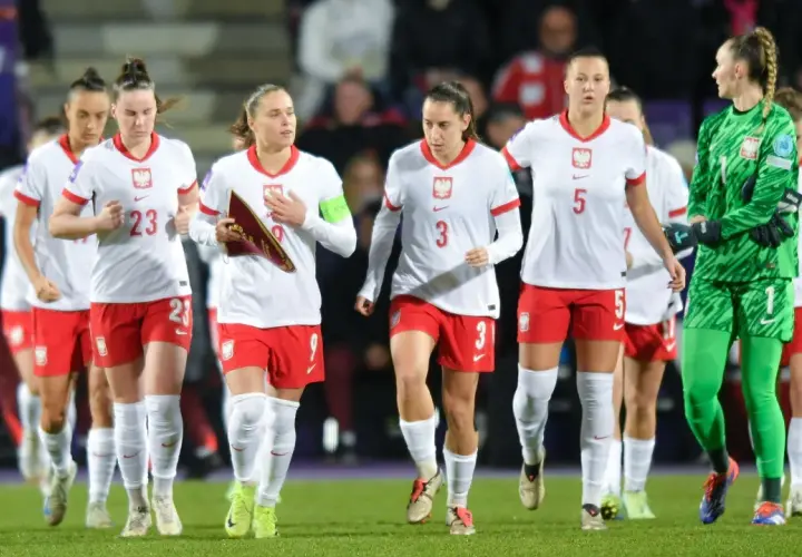 Piłkarki w biało-czerwonych strojach, dumny klub wybitnego reprezentanta, maszerują po murawie.