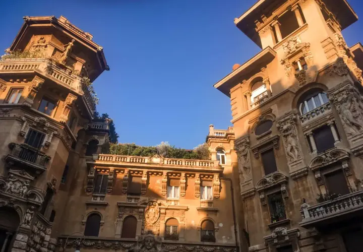 Edifici in stile liberty a Roma, con dettagli architettonici ricchi e un cielo azzurro intenso.