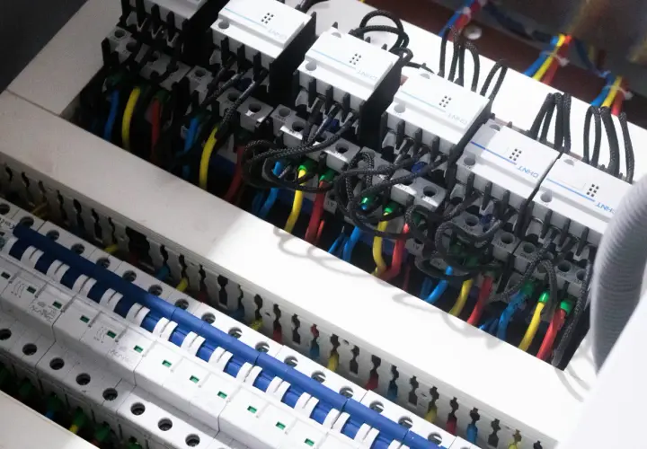 Wnętrze rozdzielnicy elektrycznej z przewodami i wyłącznikami. Widać moduły CHNT, które są częścią centrum elektrotechnicznego CB Elektron.