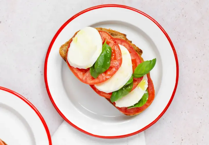 Tosta con tomate, mozzarella fresca y albahaca, inspirada en la ensalada caprese.