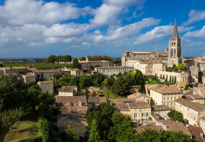Vue aérienne de Saint-Émilion, ses toits de tuiles et sa collégiale, évoquant les meilleures années Saint-Émilion Grand Cru.