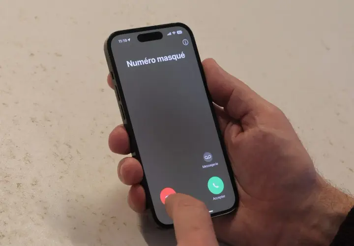 Un doigt touche le bouton rouge pour refuser un appel entrant "Numéro masqué", typique du démarchage téléphonique.