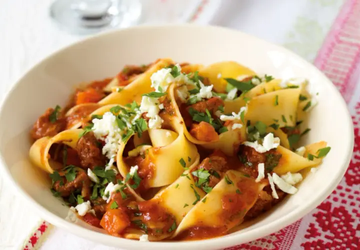 Breite Bandnudeln mit einer herzhaften Rinderhackfleischsauce und zerbröseltem Käse, ein klassisches italienisches Gericht.