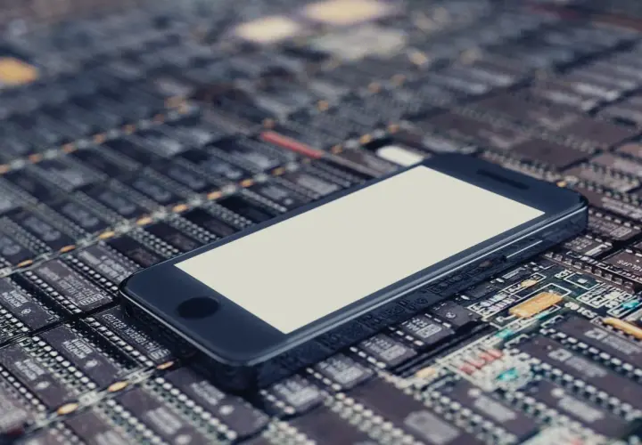 Smartfon leży na płytce drukowanej, symbolizując jego pamięć telefonu i zaawansowaną technologię.