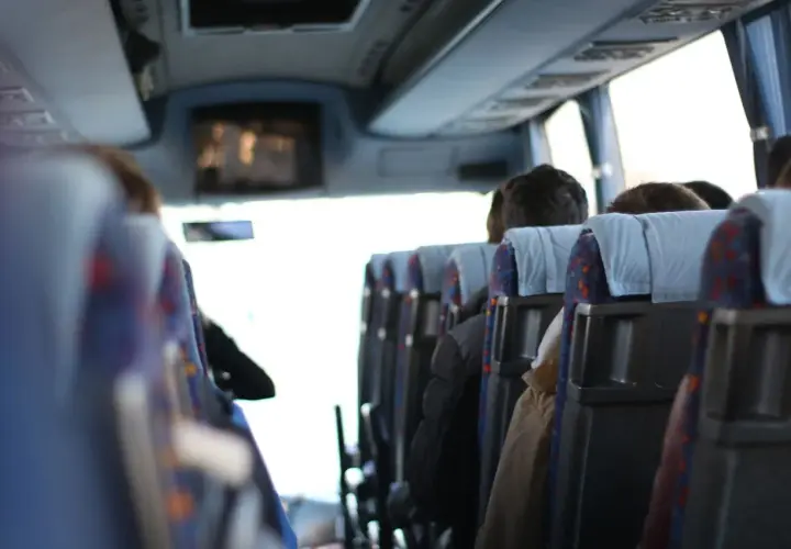 Wygodny transport gości weselnych autobusem. Widok z wnętrza pojazdu na siedzących pasażerów.