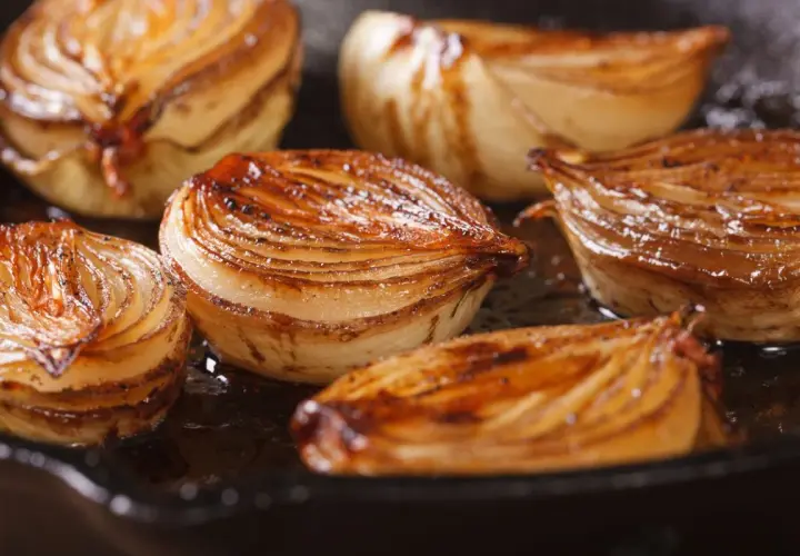 Cebolla caramelizada dorada y jugosa en una sartén.