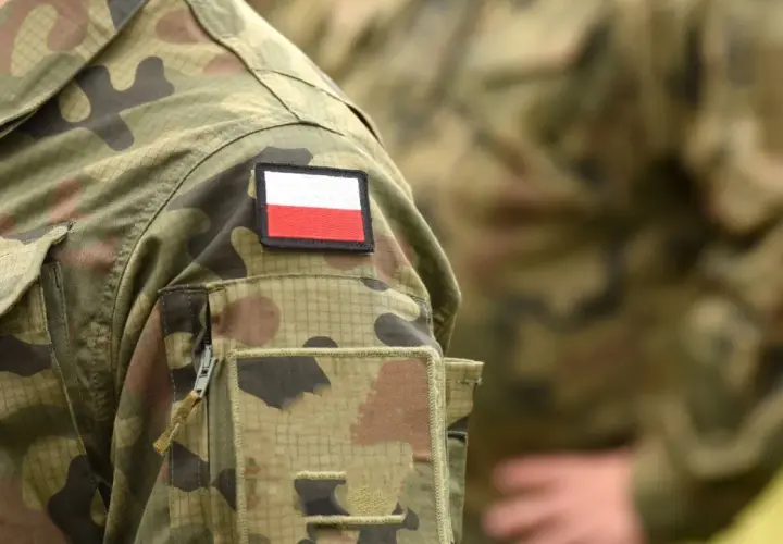 Fragment munduru wojskowego z naszywką z flagą Polski.